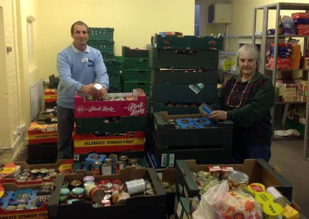 Horsham District Foodbank volunteers Phil Lawrence and Gail Tomsett sorting the pre-Christmas donations from Tesco shoppers - picture courtesy of the foodbank