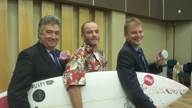 Surf's Up! Alex Bailey arrived at the meeting with a surfboard and Hawaiiin shirt in relation to the report. Pictured centre with council leaders Neil Parkin and Paul Yallop SUS-140312-084415001