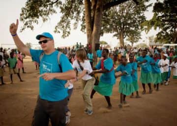 Adam Green leads WaterAid UK supporters and pupils of the Amuria Primary School in a conga celebration