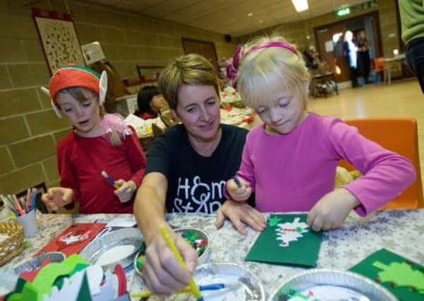 Rosin and Alice enjoy making crafts at the Home-Start CHAMS Afternoon of Christmas Song with Rachel Barr SUS-140912-154735001
