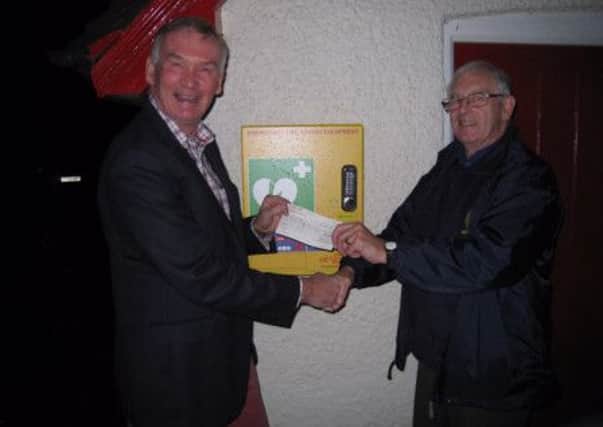 Chris Beer (left) receiving a cheque towards the new defib from Horsham Rotary Club's John Du Bois SUS-141218-152847001