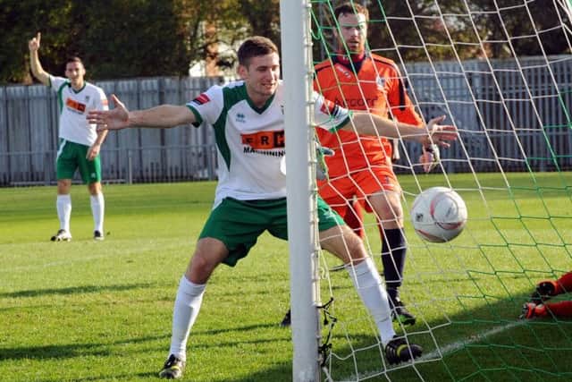 Jason Prior - in the background - watches as James Crane sees in Prior's first goal on his return to Bognor  Picture by Louise Adams