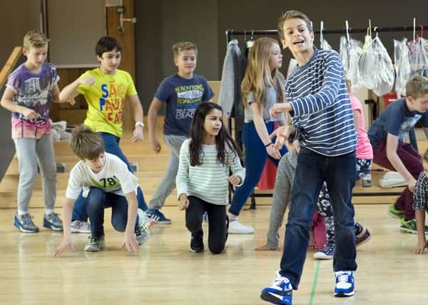 At rehearsal, Cameron Cragg (foreground) with members of the 101 Dalmatians company. Photo Mike Eddowes.