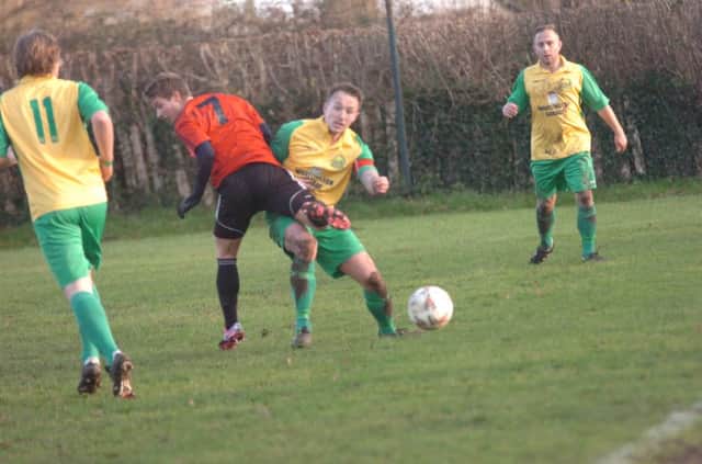 Westfield captain Gordon Cuddington halts the progress of an AFC Uckfield Town opponent. Picture by Simon Newstead (SUS-141229-092523002)