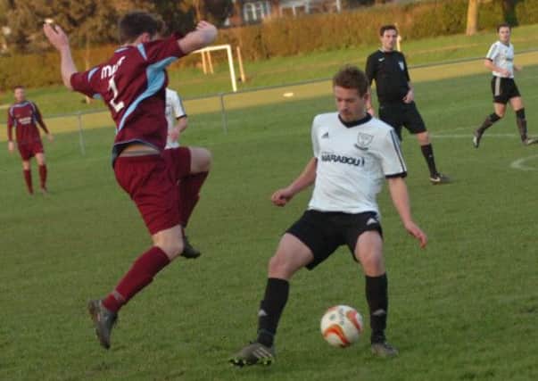 Little Common full-back Jake Sherwood takes to the air as he closes down Bexhill United midfielder Chris Cumming-Bart. Picture by Simon Newstead (SUS-141229-092928002)
