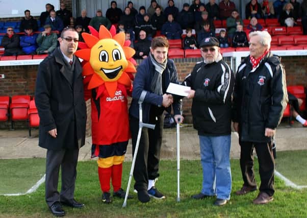 Injured Little Common footballer Dan Hill (centre) receives a cheque from Eastbourne Borough SUS-151201-102538002
