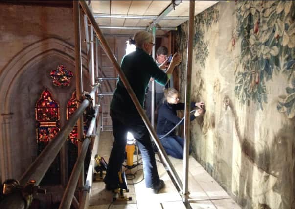 Conservators busy cleaning and restoring the Barons Halls Gobelin tapestry