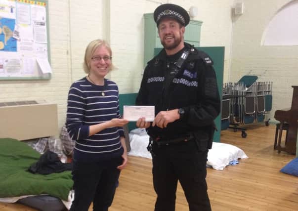 PC James Munden presents a cheque to Horsham Matters