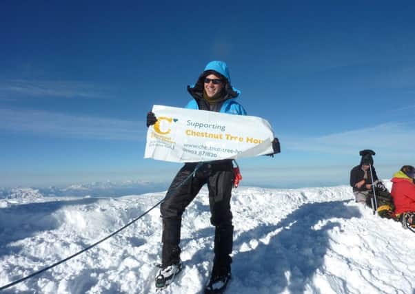 Rupert Jones-Warner with the Chestnut Tree House banner at the peak of Mont Blanc in September