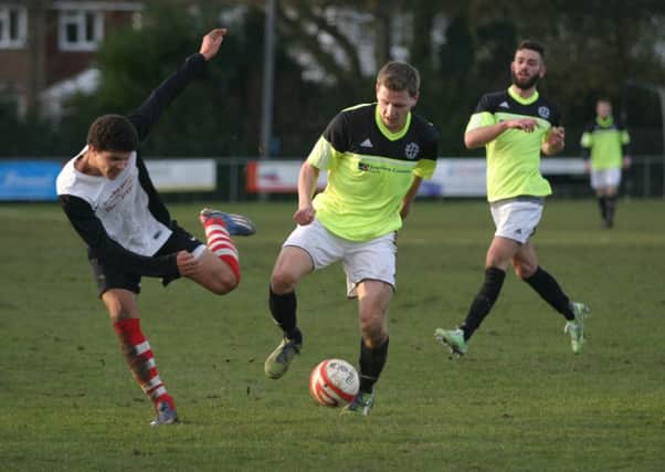Taylor Smith (left) in action for Horsham YM being challenged by SFR defender. Pictured far right Matt Godly, who scored SFR second goal. Photo by Clive Turner