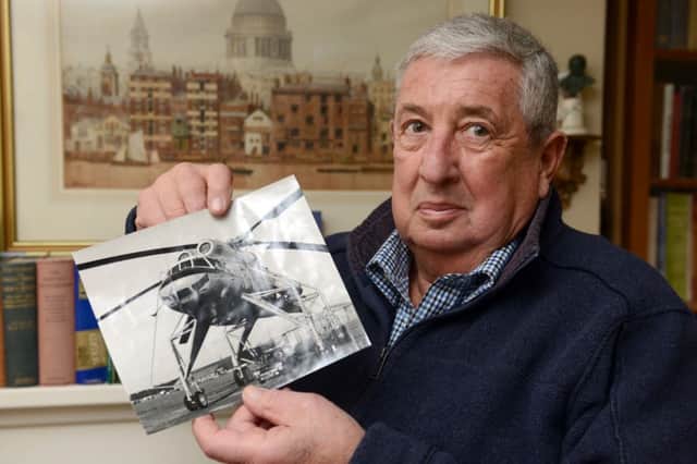 LG 270115 David Kay, whose helicopter firm helped to cover the funeral of Sir Winston. Holding a photo of a helicopter he once owned. Photo by Derek Martin SUS-150127-231341001