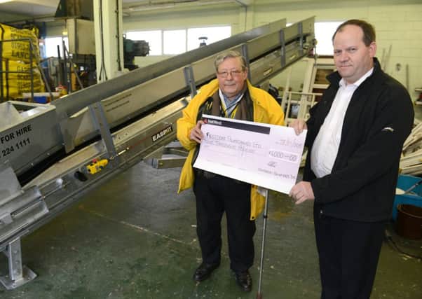 LH 280115 Freedom powerchairs (a local mobility charity) receives a cheque for £4,000 from one of their suppliers. Martin Osment left receives the cheque from Martin Pillar of Easikit Modular Conveyors. Photo by Derek Martin SUS-150128-113638001