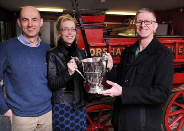 JPCT 300115 S15050341x Fact Not Fiction Films are to make a documentary on the life story of early 20th century athlete Alfred Shrubb. Horsham Museum. Tristan Loraine, Sarah Hamson and Cliff Comber with one of Shrubb's trophies and in front of fire engine he possibly ran after -photo by Steve Cobb SUS-150130-155837001