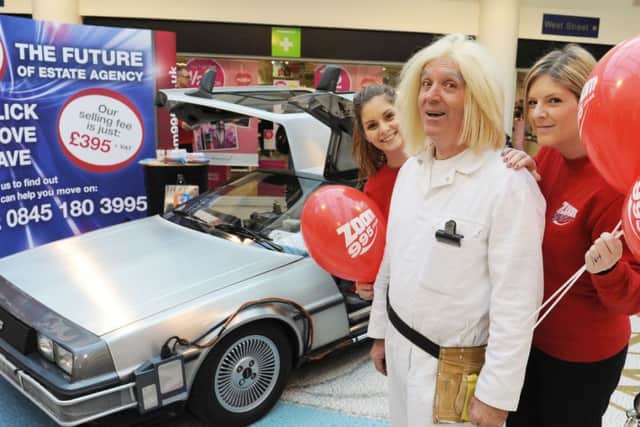 JPCT 070215 S15060165x Back to the Future car in Swan Walk, Horsham. Lottie Dove, car owner Brian O'Neill and Stacey James -photo by Steve Cobb SUS-150702-110816001