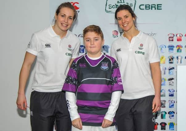 Taylor Clarke shows off Felpham Community College's kit design, with Sarah Hunter and Emily Scarratt