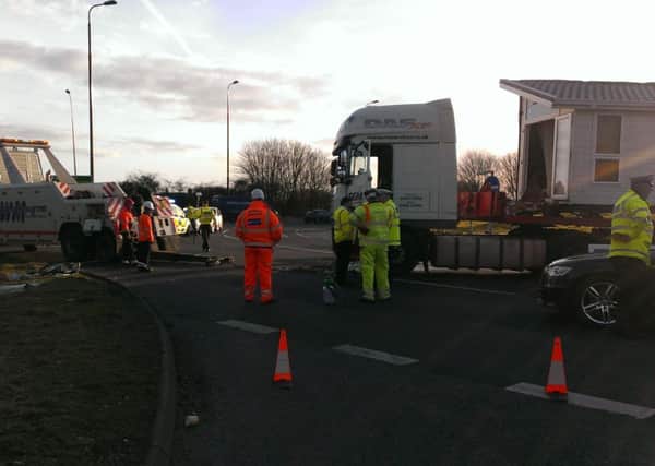 Recovery crews were trying to move the lorry. The car was already loaded onto a truck