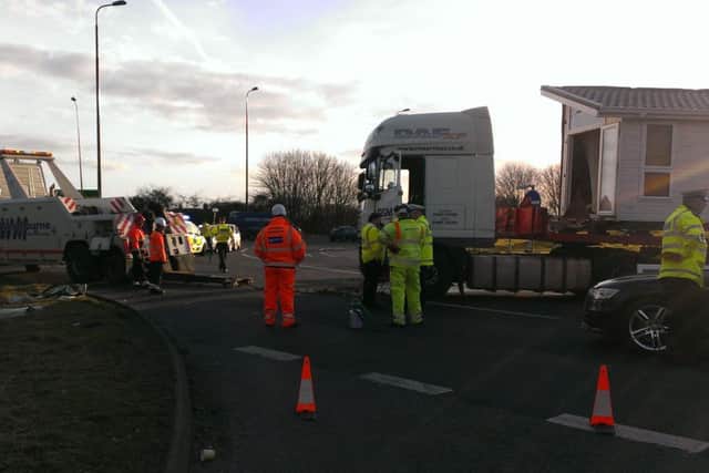 Recovery crews were trying to move the lorry. The car was already loaded onto a truck