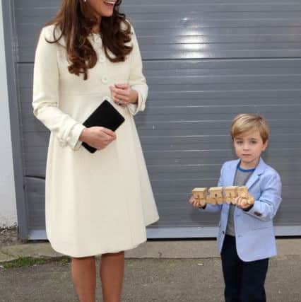 The Duchess of Cambridge is presented with a train for Prince George by actor Oliver Barker during an official visit to the set of Downton Abbey at Ealing Studios in London. PRESS ASSOCIATION Photo. Picture date: Thursday March 12, 2015. See PA story ROYAL Kate. Photo credit should read: Chris Jackson/PA Wire ROYAL_Kate_143229.JPG