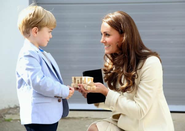The Duchess of Cambridge is presented with a train for Prince George by actor Oliver Barker during an official visit to the set of Downton Abbey at Ealing Studios in London. PRESS ASSOCIATION Photo. Picture date: Thursday March 12, 2015. See PA story ROYAL Kate. Photo credit should read: Chris Jackson/PA Wire ROYAL_Kate_141172.JPG