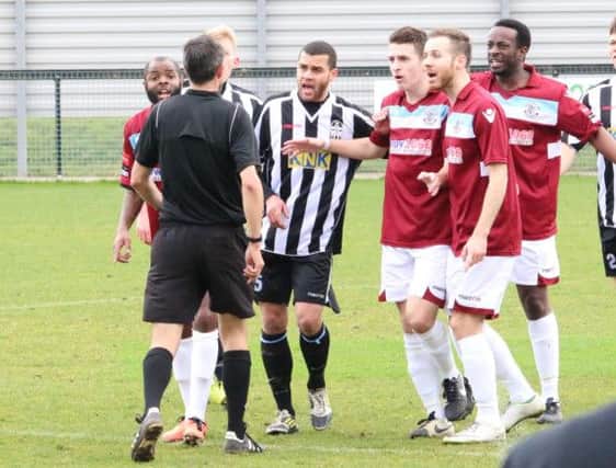 Players surround the referee during Hastings United's 1-1 draw away to Tooting & Mitcham United last weekend. Picture courtesy Joe Knight