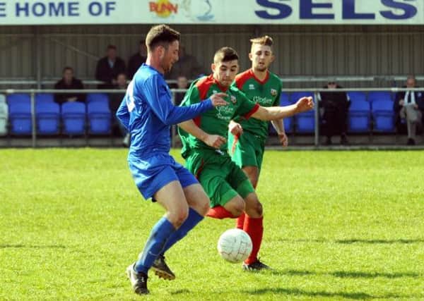 Selsey's Sam Agostinelli (in blue) in action against Pagham / Picture by Louise Adams LA1500064-7