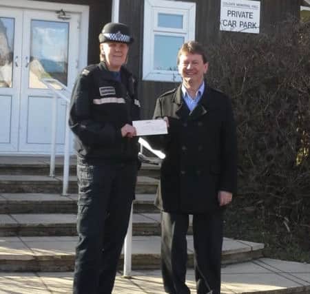 PCSO Tracy Bicknell presents a cheque to David Elder of the Colgate Memorial Hall Management Committee