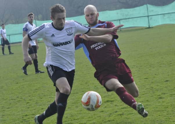 Little Common player-manager Russell Eldridge challenges Bexhill United midfielder Chris Cumming-Bart on Easter Monday. Picture by Simon Newstead (SUS-150604-184518002)