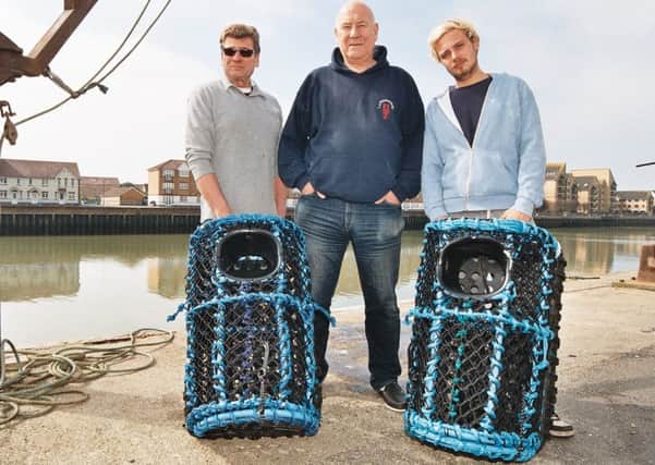 Chris Huxtable, Jim Partridge and Will Howarth at the quay with two of the new pots PICTURE: JOHN PERIAM