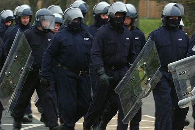 Officers pictured wearing body armour and preparing to break up the prison riot in 2011