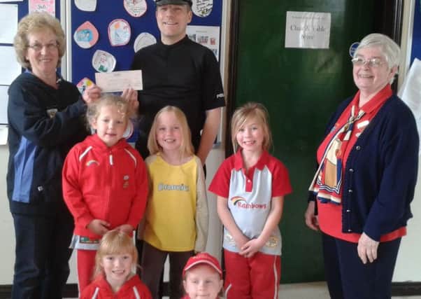 Special Constable Worth pictured presenting the cheque to members of Chanctonbury Rainbows and Brownies.