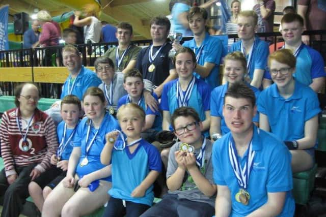Some of the happy swimmers with their medals along with two of Mid Sussex Marlins' invaluable helpers.