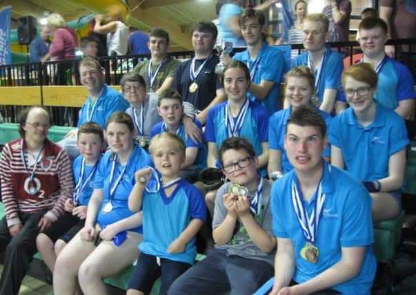 Some of the happy swimmers with their medals along with two of Mid Sussex Marlins' invaluable helpers.