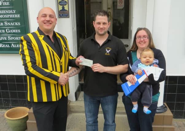 President of Littlehampton Rugby Club, Mark Quinney, left, handing over a fundraising cheque to Craig Walters. Craig is pictured with his wife Kerry and son Archie-John SUS-151105-174307001