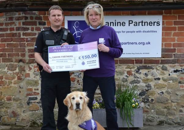 PC Paul Quinnell presents a cheque to regional fundraiser Jane Grant and demonstration dog Angel.