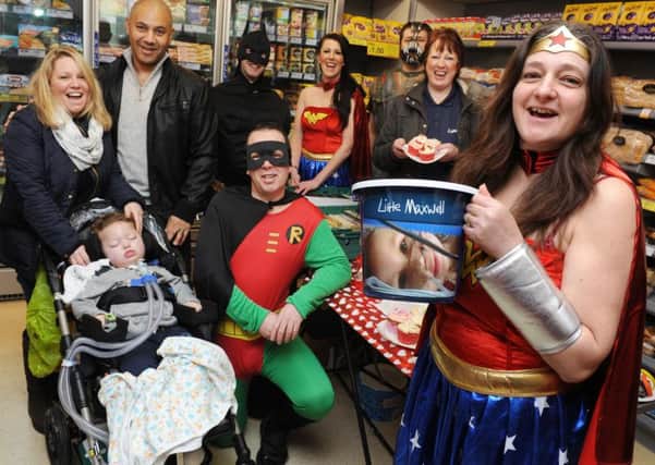 Little Maxwell with his parents, Emma and Pete, along with Tesco Express staff during a fundraiser last year