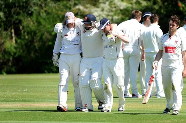 Injured Bexhill batsman James Walker is helped off during last weekend's defeat at Horsham. Picture by Steve Robards (SUS-150518-174317001)