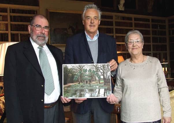 Roy Tanner, left, the 3,000th member of 
the Wey & Arun Canal Trust, and his wife Caroline receive a commemorative certificate from Lord Egremont at Petworth House. SUS-150406-154200001