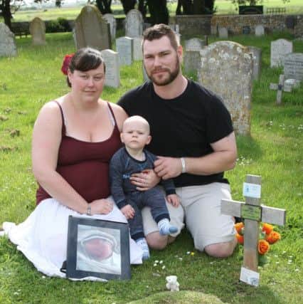The family by the grave of baby Grayson