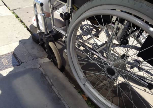 A wheelchair wheel stuck outside the Messam's shop in East Street