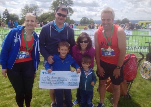 Mark and Sadie Middleon hand the cheque to the Booker family at the Petworth Discovery Half Marathon