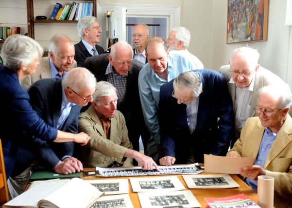 Former choristers from The Prebendal School looking at old photographs during the reunion ks1500237-2