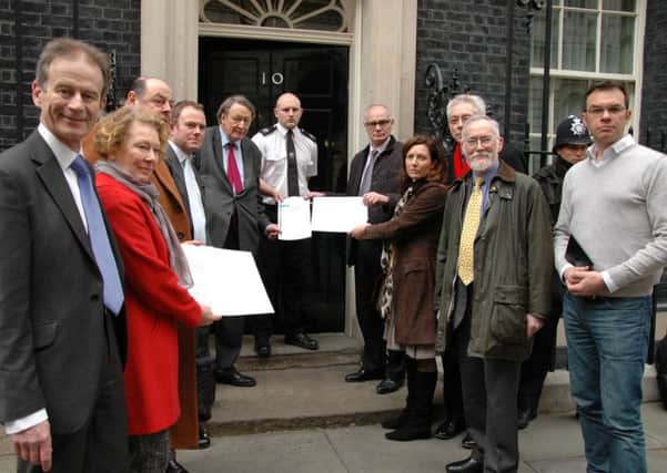 Members of CAGNE present a letter at 10 Downing Street SUS-150324-135048001