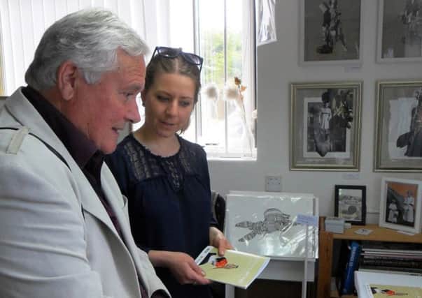 Linda Bernhard, one of the studios members, showing mayor Michael Donin one of her recent collages