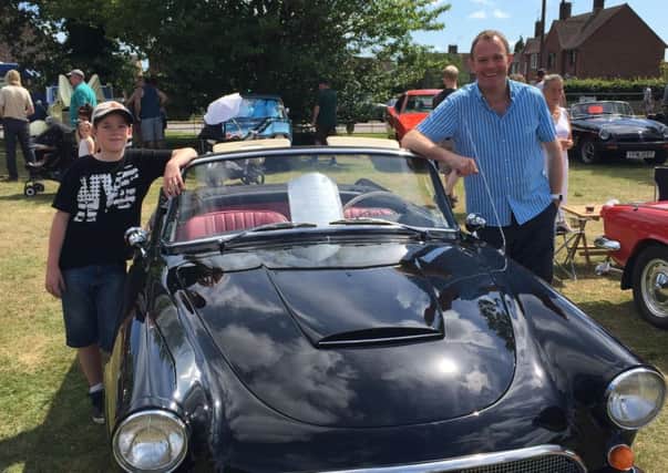 Nick Herbert MP with Adam Bidwell, 11, next to the winner of the classic car competition at the Cowfold Festival SUS-150707-141955001