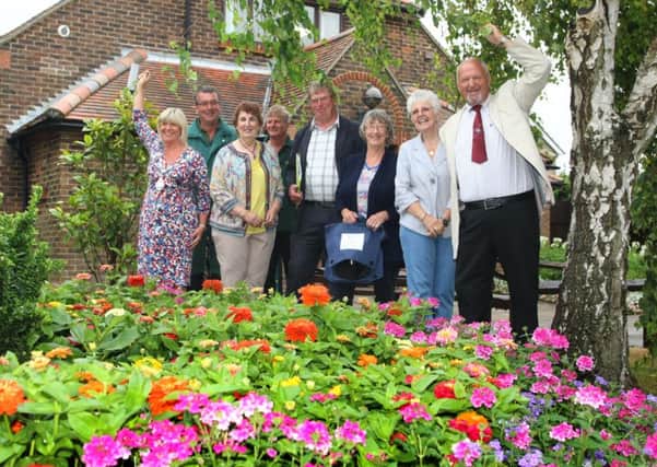 Judges and villagers, including parish council chairman Alison Cooper (far left) admire a floral display DM1515465