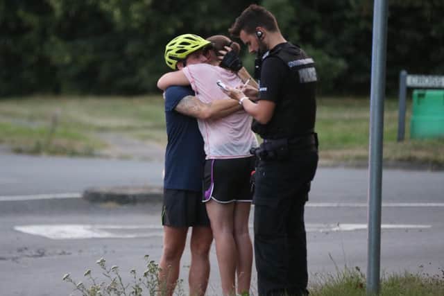A male cyclist and a woman embrace following the man's death
