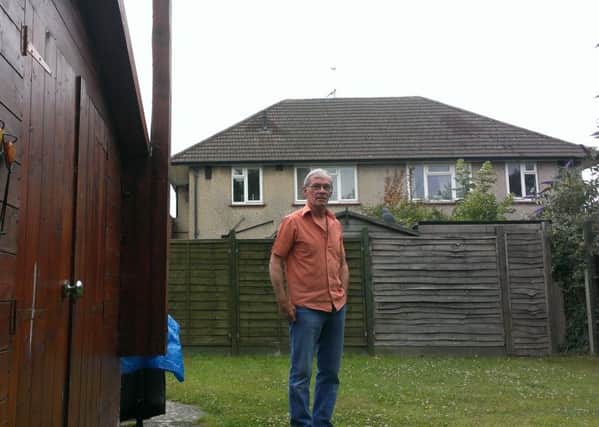 Bob Stone in his garden with his home behind him