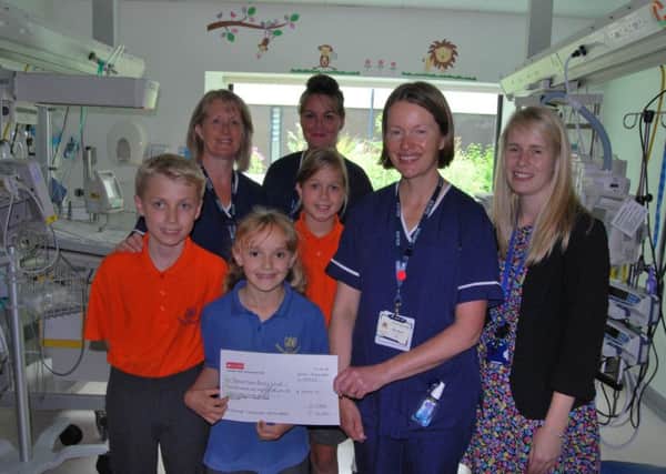 Bonnie Cuff, seven, from Guestling Bradshaw School presents Neonatal Sister Alison Mardell with donation