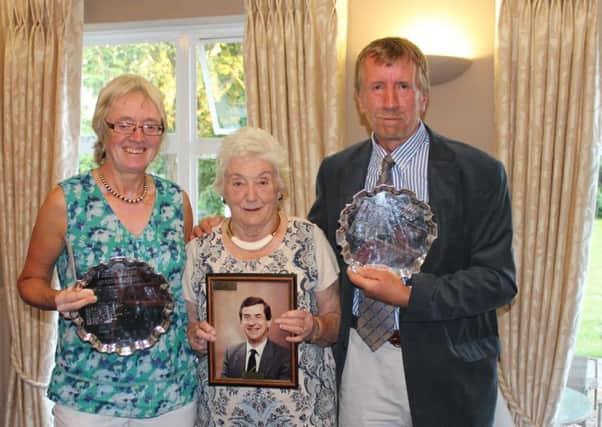 Liz and Andy being presented with their Salvers by Margaret, who holds a picture of her late husband.