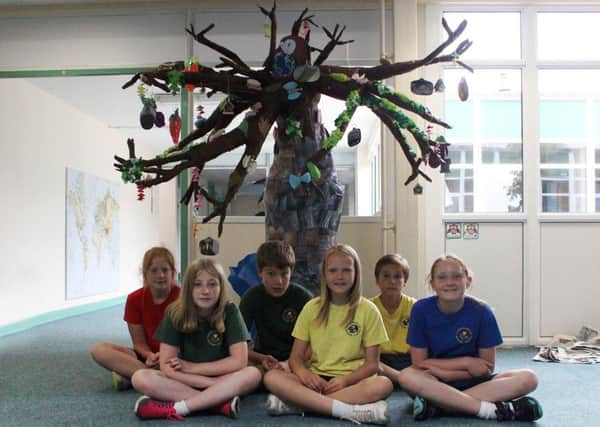 Easebourne Primary School pupils who have created a magical tree out wire, paper mache and their own photographs